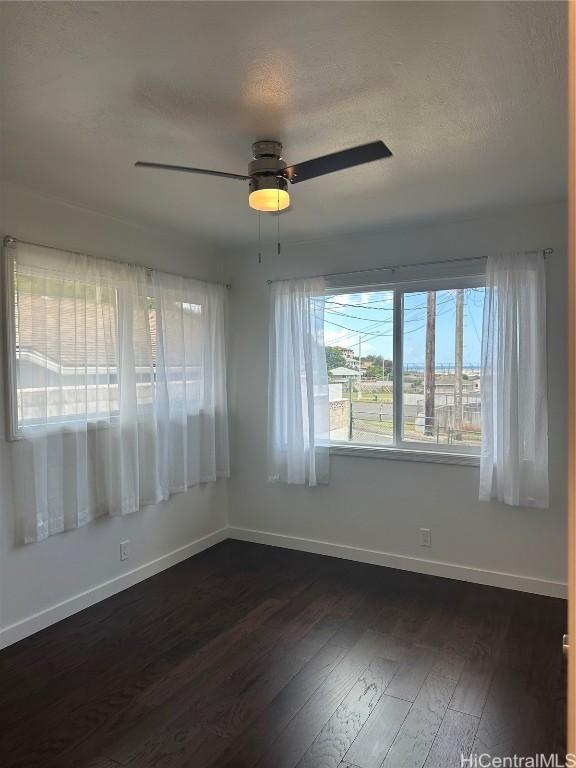 spare room with ceiling fan, dark hardwood / wood-style flooring, and a textured ceiling