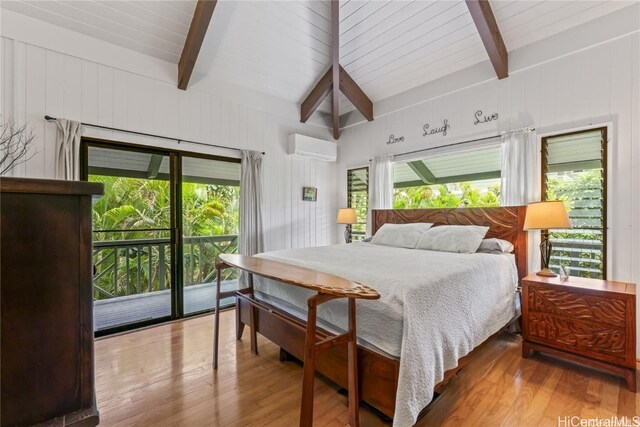 bedroom with hardwood / wood-style flooring, access to exterior, a wall unit AC, and beam ceiling