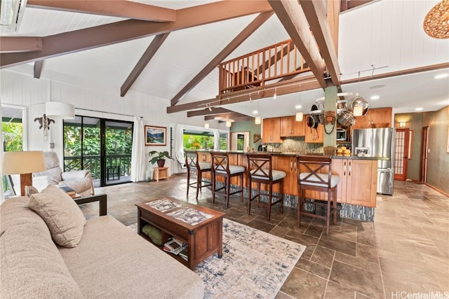 living room featuring beamed ceiling and high vaulted ceiling