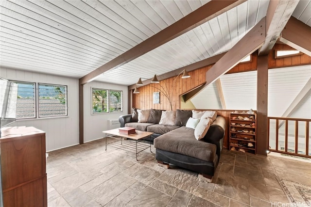 living room featuring beam ceiling and wood walls