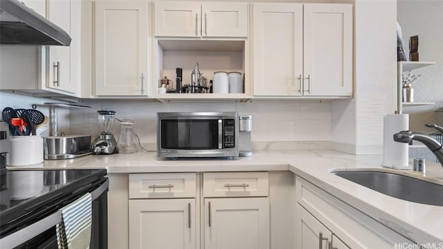 kitchen featuring exhaust hood, white cabinetry, sink, and stainless steel appliances