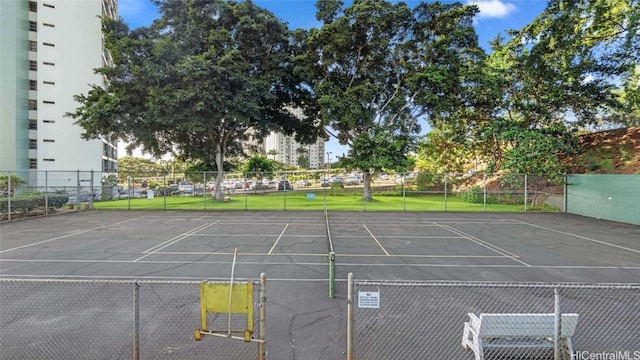 view of car parking with tennis court