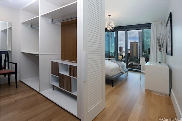 walk in closet featuring an inviting chandelier and wood finished floors