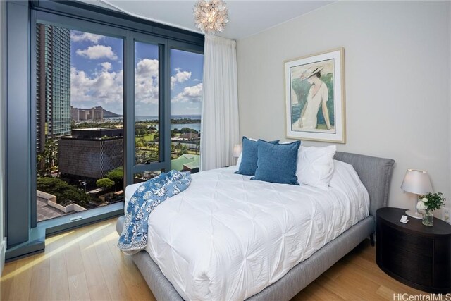 bedroom with hardwood / wood-style floors and a notable chandelier