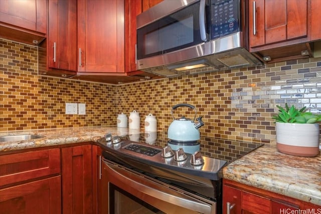 kitchen with light stone countertops and tasteful backsplash