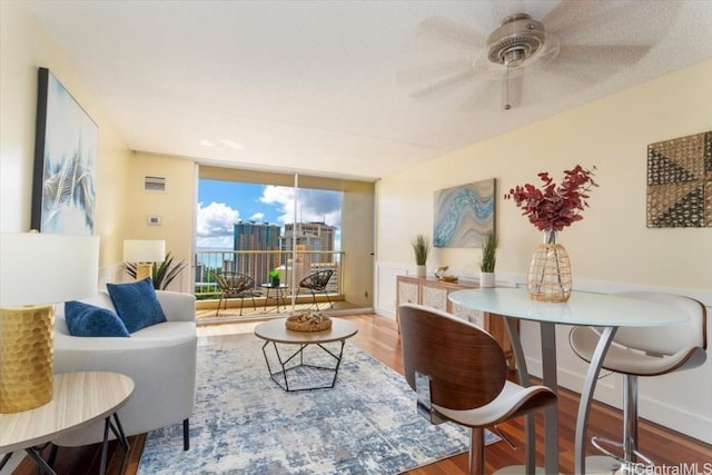 sitting room with hardwood / wood-style floors and ceiling fan