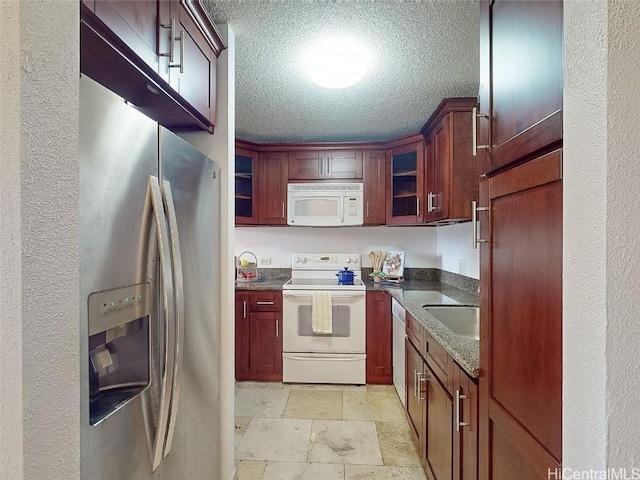 kitchen featuring sink, a textured ceiling, appliances with stainless steel finishes, and dark stone counters