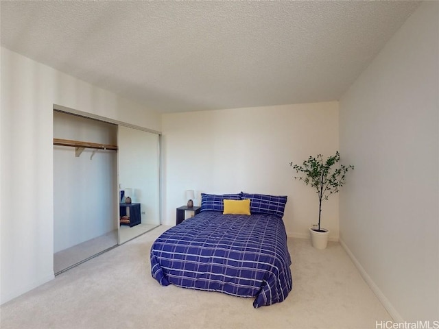 bedroom featuring carpet flooring, a closet, and a textured ceiling