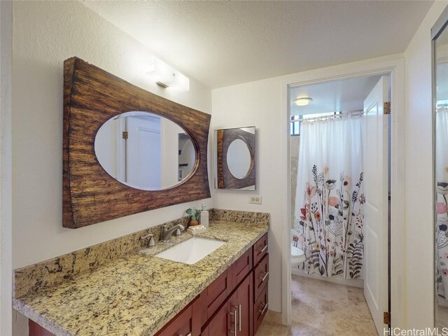 bathroom with vanity, a shower with shower curtain, and toilet