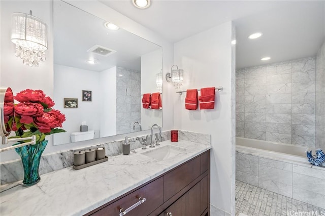 full bathroom featuring tile patterned flooring, vanity, tiled shower / bath combo, and toilet