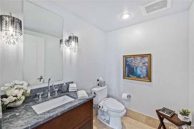 bathroom with tile patterned flooring, vanity, an inviting chandelier, and toilet