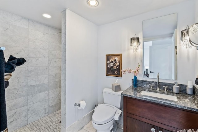 bathroom with tiled shower, tile patterned flooring, vanity, and toilet