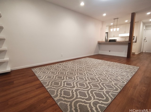 unfurnished living room featuring dark wood finished floors, recessed lighting, and baseboards