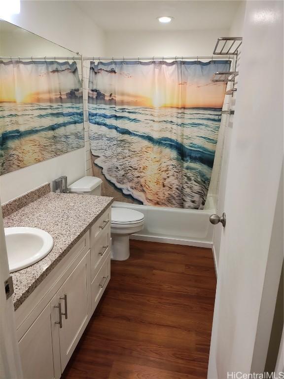 full bathroom with vanity, wood-type flooring, shower / tub combo, and toilet