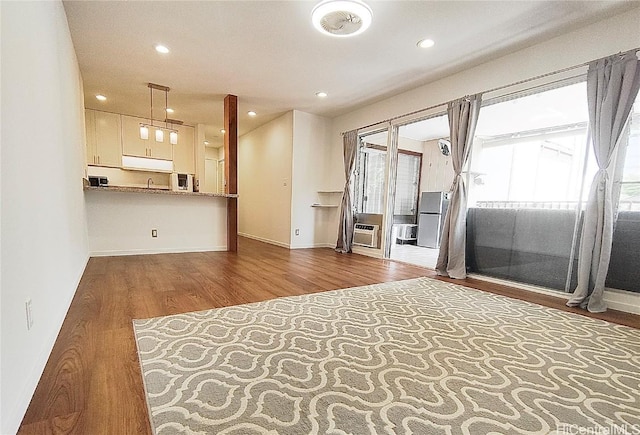 unfurnished living room with recessed lighting, baseboards, and wood finished floors