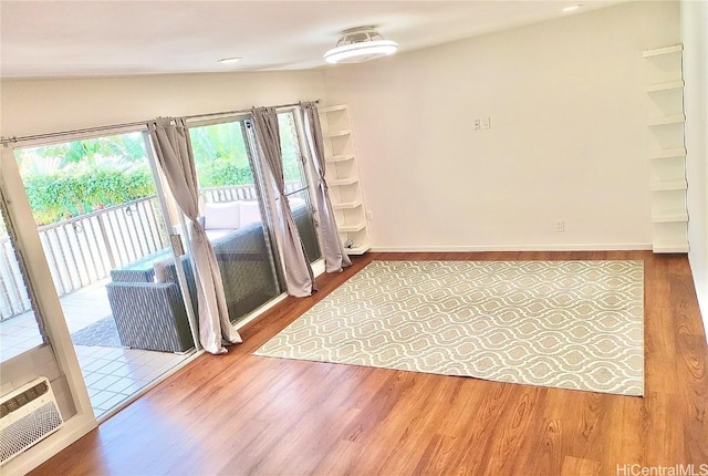 spare room with baseboards and wood finished floors