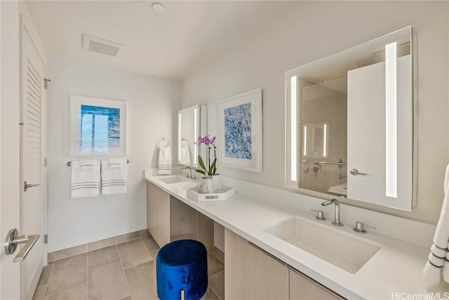 bathroom featuring tile patterned flooring, vanity, and tiled shower