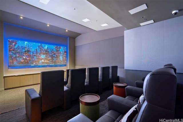 home theater featuring vaulted ceiling and dark carpet