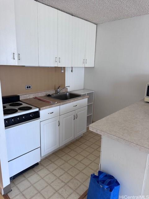 kitchen with white cabinets, a textured ceiling, white range with electric stovetop, and sink