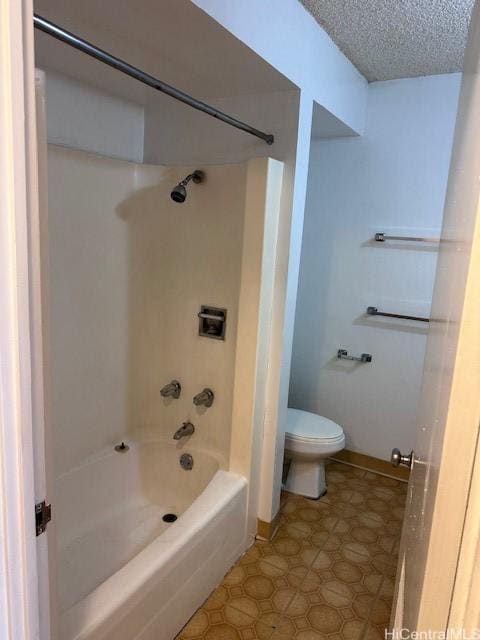 bathroom with a textured ceiling, shower / bath combination, and toilet