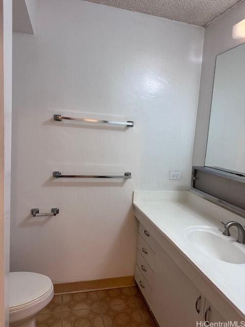 bathroom featuring vanity, toilet, and a textured ceiling