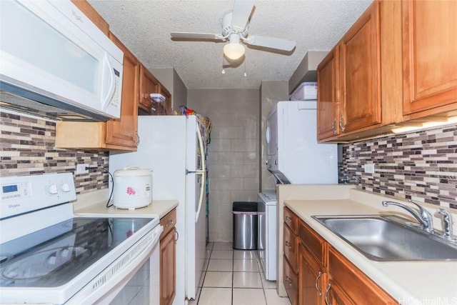 kitchen with white appliances, sink, ceiling fan, light tile patterned floors, and a textured ceiling