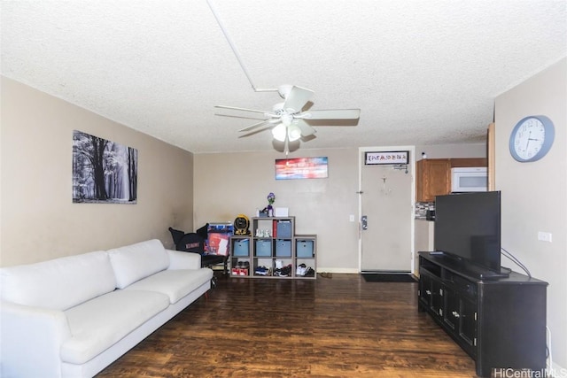 living room featuring a textured ceiling, ceiling fan, and dark hardwood / wood-style floors