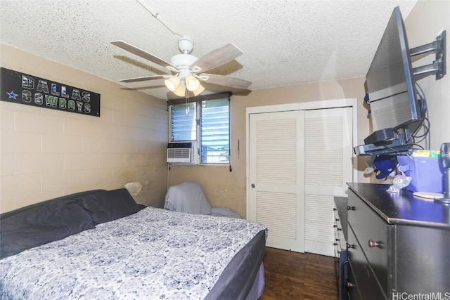 bedroom featuring a textured ceiling, dark hardwood / wood-style floors, a closet, and ceiling fan