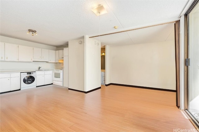 kitchen featuring a textured ceiling, white electric range, white cabinets, washer / dryer, and light hardwood / wood-style floors