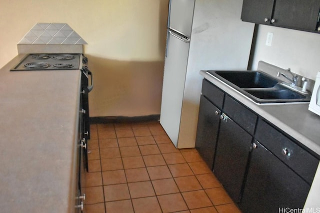 kitchen with sink, light tile patterned floors, and stove