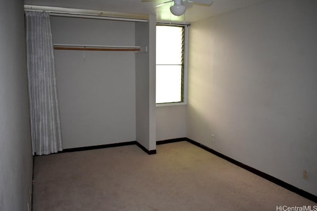 unfurnished bedroom featuring ceiling fan, light carpet, and a closet