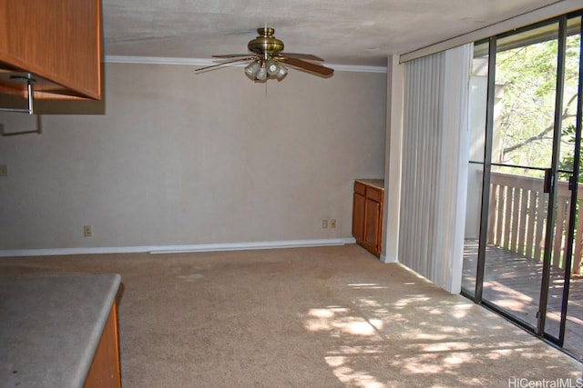 interior space with light carpet, expansive windows, ceiling fan, and ornamental molding