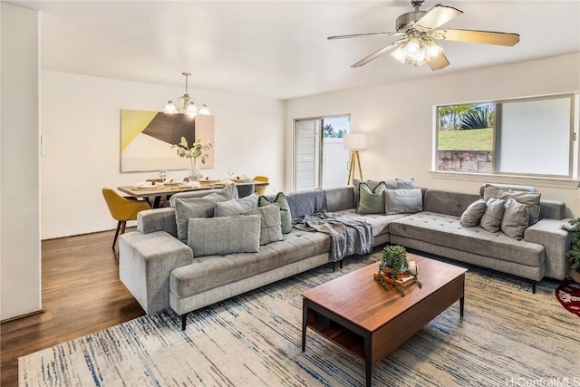 living room with hardwood / wood-style floors and ceiling fan with notable chandelier