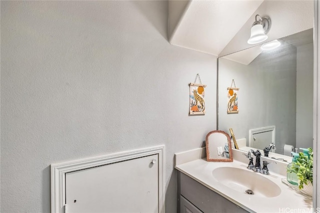 bathroom featuring vanity and lofted ceiling