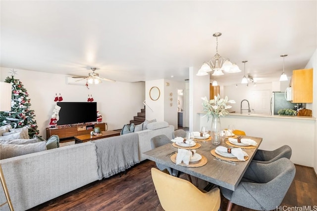 dining area featuring sink, dark wood-type flooring, and ceiling fan with notable chandelier