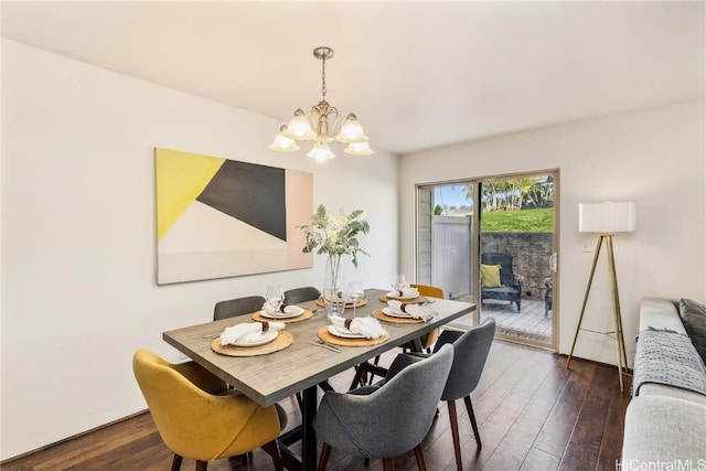 dining room with dark wood-type flooring and an inviting chandelier