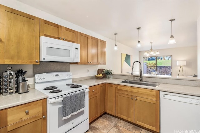 kitchen featuring sink, pendant lighting, white appliances, and a notable chandelier