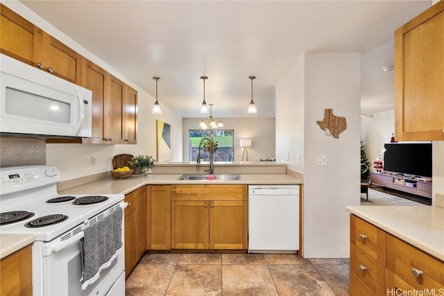 kitchen with white appliances, sink, decorative light fixtures, a notable chandelier, and kitchen peninsula