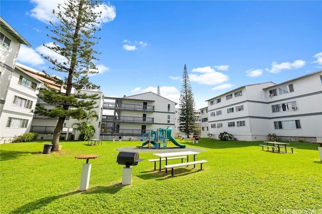 view of home's community with a playground and a yard