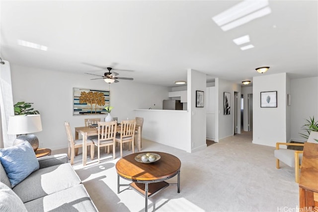 living room with ceiling fan and light colored carpet