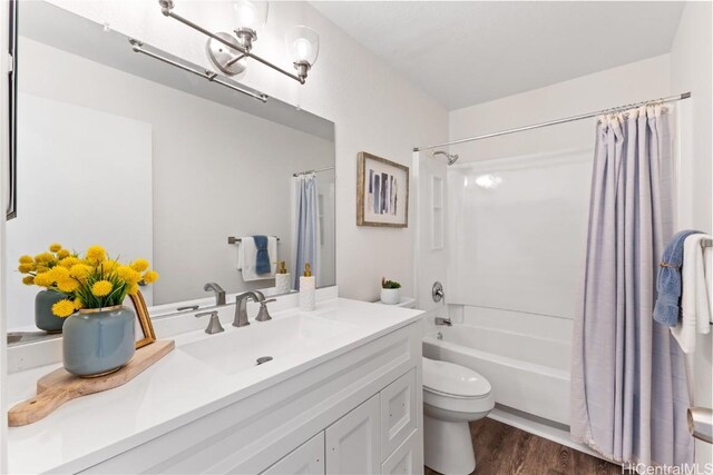 full bathroom with hardwood / wood-style floors, vanity, shower / bath combination with curtain, and toilet