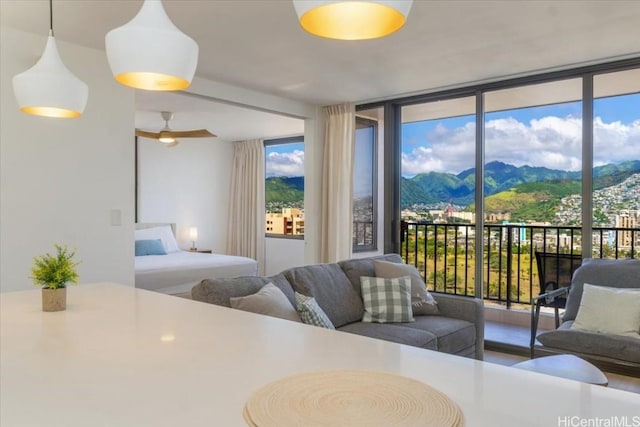 bedroom with floor to ceiling windows, a mountain view, and access to exterior