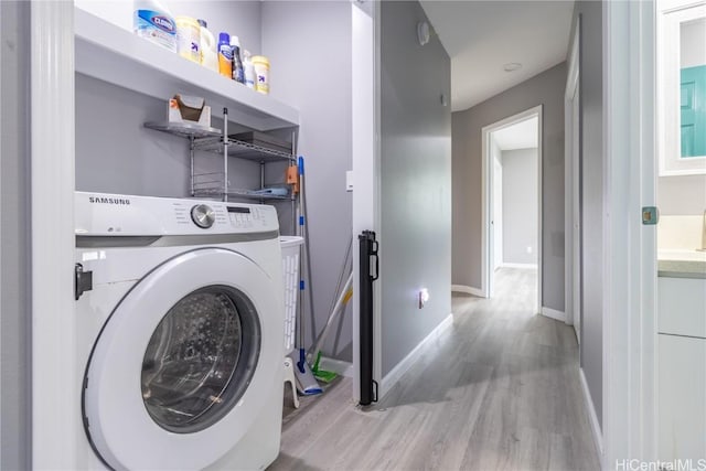 laundry room with washer / dryer and light wood-type flooring