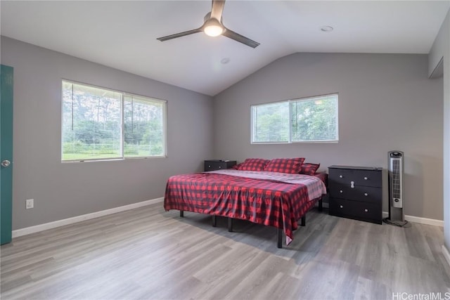 bedroom with ceiling fan, light hardwood / wood-style floors, and vaulted ceiling