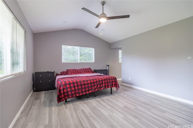 bedroom featuring ceiling fan, lofted ceiling, light wood-type flooring, and multiple windows