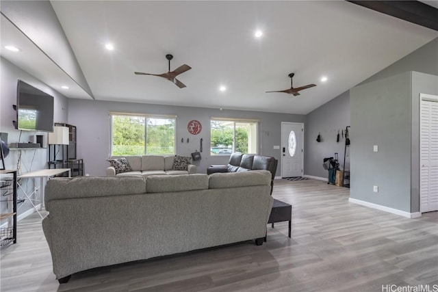 living room featuring light hardwood / wood-style flooring, vaulted ceiling, and ceiling fan