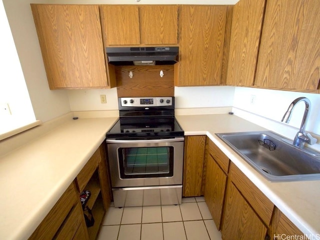 kitchen with light tile patterned floors, stainless steel electric range oven, and sink