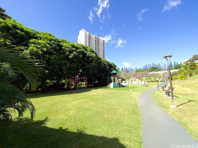 view of property's community with a playground and a yard