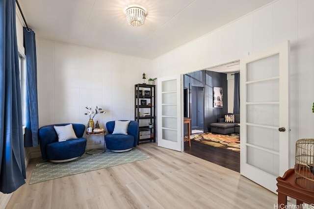 sitting room featuring hardwood / wood-style floors, built in features, and french doors