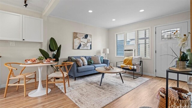 living room featuring light hardwood / wood-style floors and ornamental molding